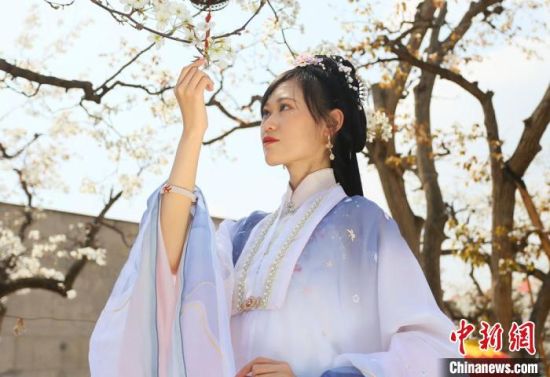 圖為蘭州青年身穿漢服在百年梨園賞景?！「哒?攝