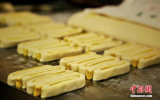 圖為面劑被涂上胡麻油，切成條狀用作月餅的花型制作。張文 攝