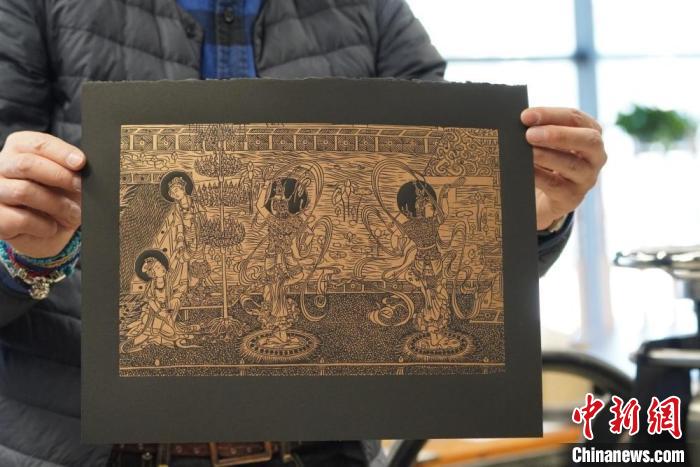 圖為手工書藝人展示敦煌雕版壁畫印刷品?！【琶赖┰?　攝