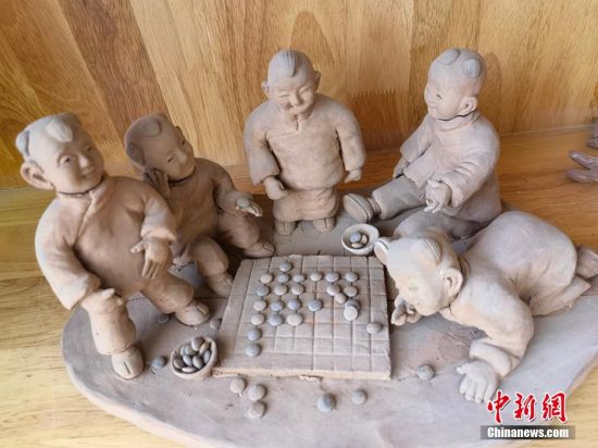 圖為泥塑作品展現(xiàn)下棋場景。 劉玉桃 攝