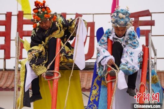 圖為“苦水高高蹺”表演者通過麻繩將腳固定在腳踏板，并在腿部纏繞六七圈?！【琶赖┰?攝