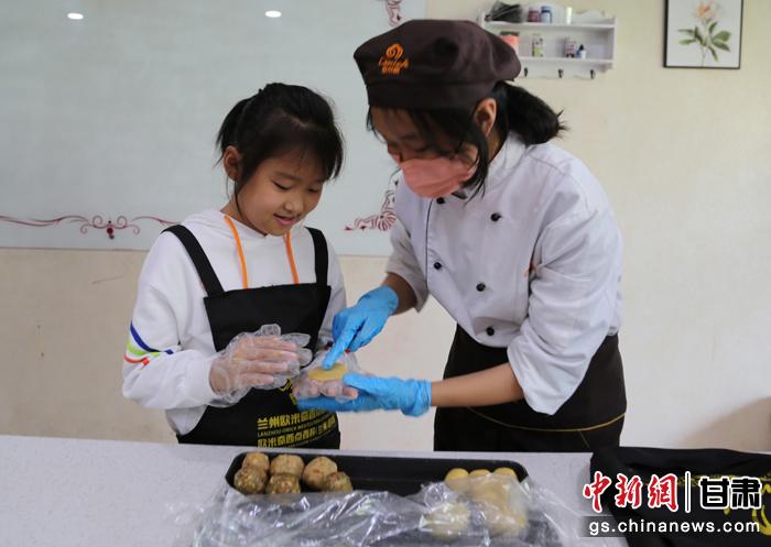 圖為在甘臺(tái)胞小朋友在工作人員指導(dǎo)下制作月餅。九美旦增 攝