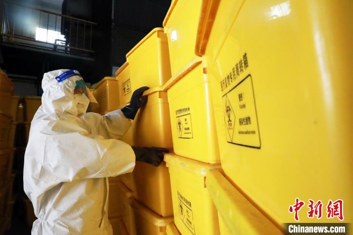 圖為工作人員搬運(yùn)醫(yī)療廢物專用周轉(zhuǎn)箱?！∥航ㄜ?攝