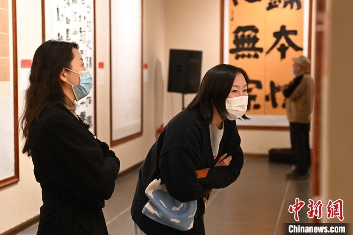 圖為甘肅蘭州，參展書(shū)法作品吸引參觀者。 中新社記者 李亞龍 攝