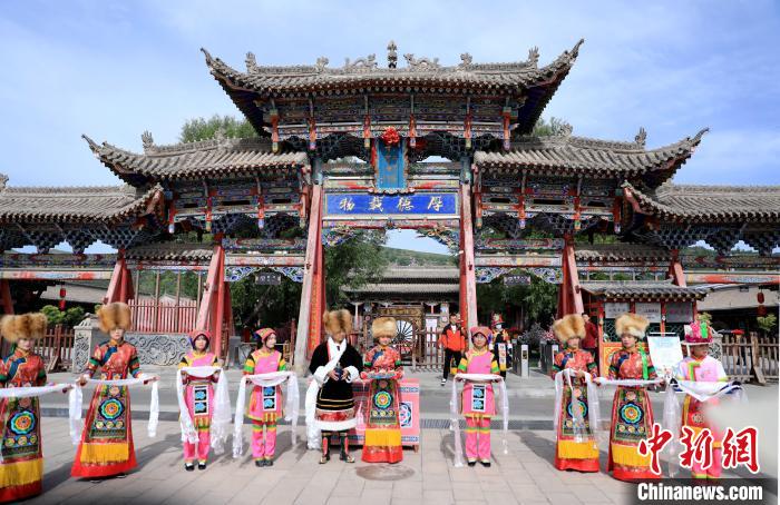 圖為身穿土族服飾的工作人員迎接訪客?！⊙Φ?攝