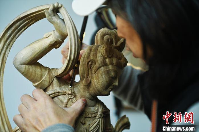 圖為季茂杰進行敦煌元素的木雕創(chuàng)作。李亞龍 攝</p>
<p>