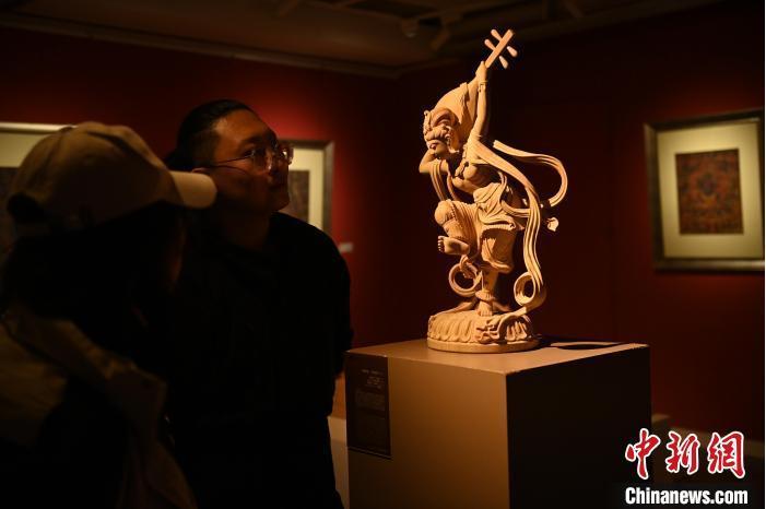 圖為季茂杰向參觀者介紹自己創(chuàng)作敦煌木雕的過程。李亞龍 攝</p>
<p>