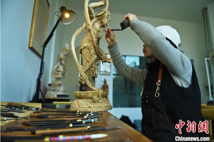 圖為季茂杰進行敦煌元素的木雕創(chuàng)作。李亞龍 攝</p>
<p>