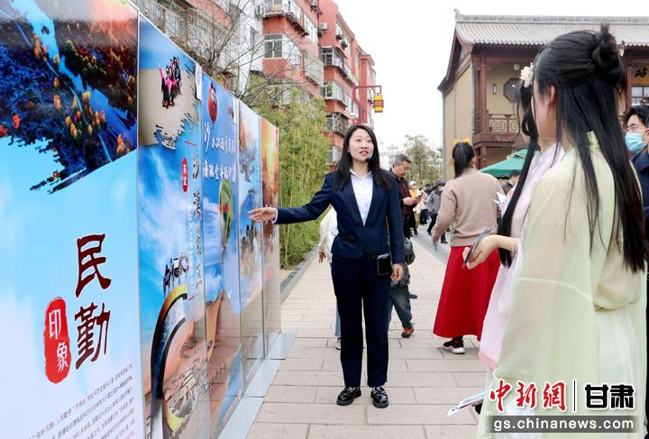 3月下旬，民勤縣在天水啟漢樓廣場(chǎng)舉行推介會(huì)，宣傳本地旅游資源和農(nóng)特優(yōu)產(chǎn)品。圖為工作人員向游客介紹民勤自然風(fēng)光、歷史文化。馬愛彬 攝