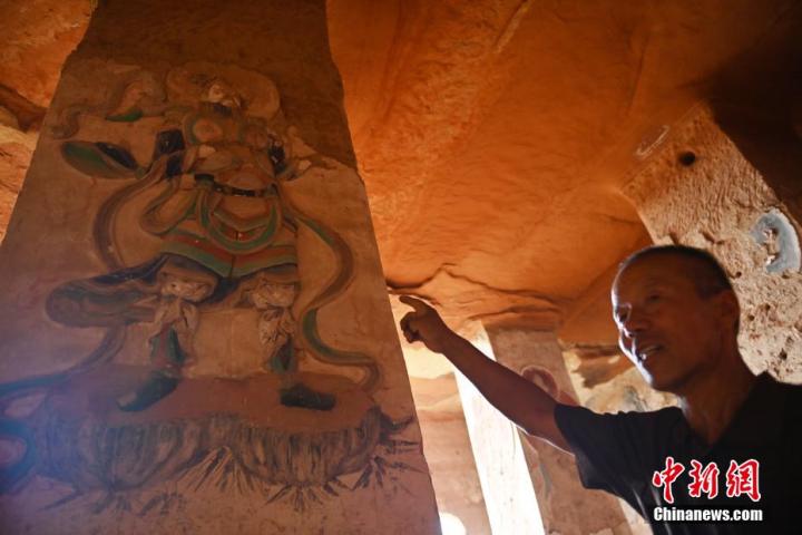 7月15日，甘肅省平?jīng)鍪袥艽h百里石窟長廊羅漢洞石窟內(nèi)，該窟文保員郭建平介紹窟內(nèi)石刻彩繪壁畫。郭建平家中三代人曾自發(fā)保護(hù)羅漢洞石窟。羅漢洞石窟遺存40余個窟龕，以北魏至清代風(fēng)格為主。中新社記者 李亞龍 攝</p>
<p>