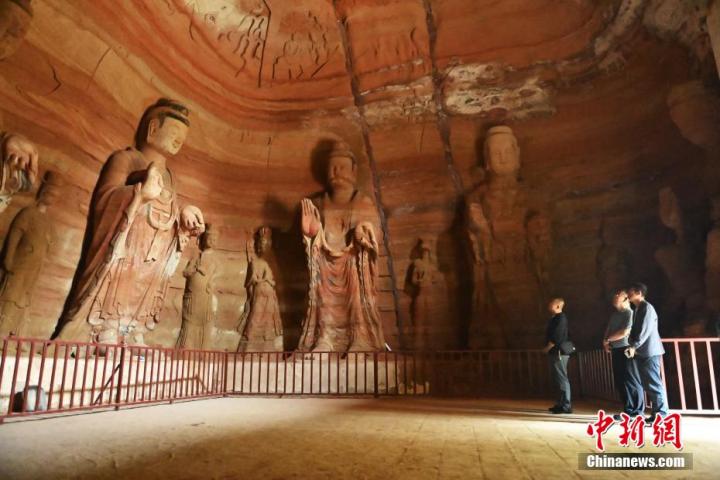 7月15日，游人參觀甘肅省平?jīng)鍪袥艽h百里石窟長廊中的南石窟寺1號窟。百里石窟長廊位于涇川縣境內(nèi)，由512個石窟、5眼窟中石井組成，現(xiàn)存王母宮石窟、鳳凰山石窟、南石窟寺、丈八寺石窟、羅漢洞石窟、太山寺石窟等規(guī)模較大的石窟群，還有數(shù)量眾多的小石窟群。南石窟寺開鑿于北魏永平三年，其中1號窟屬于大型七佛窟，七佛高達(dá)6米。中新社記者 李亞龍 攝