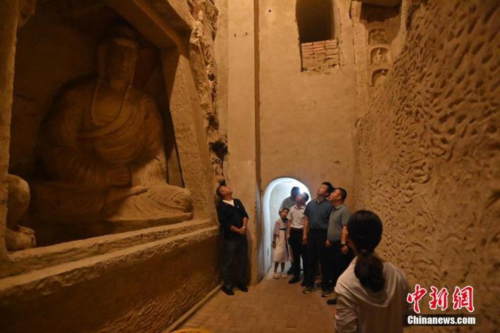 7月15日，游人參觀甘肅省平?jīng)鍪袥艽h百里石窟長廊中的王母宮石窟。百里石窟長廊位于涇川縣境內(nèi)，由512個石窟、5眼窟中石井組成，現(xiàn)存王母宮石窟、鳳凰山石窟、南石窟寺、丈八寺石窟、羅漢洞石窟、太山寺石窟等規(guī)模較大的石窟群，還有數(shù)量眾多的小石窟群。王母宮石窟又名千佛洞，該窟設(shè)計宏大，造像生動，窟內(nèi)擁有造像數(shù)百尊，是較為珍貴的佛教文化歷史遺存。中新社記者 李亞龍 攝</p>
<p>