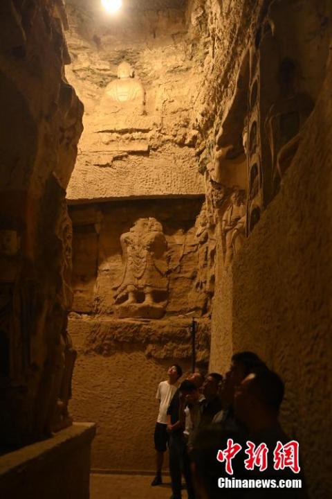 7月15日，游人參觀甘肅省平?jīng)鍪袥艽h百里石窟長廊中的王母宮石窟。百里石窟長廊位于涇川縣境內(nèi)，由512個石窟、5眼窟中石井組成，現(xiàn)存王母宮石窟、鳳凰山石窟、南石窟寺、丈八寺石窟、羅漢洞石窟、太山寺石窟等規(guī)模較大的石窟群，還有數(shù)量眾多的小石窟群。王母宮石窟又名千佛洞，該窟設(shè)計宏大，造像生動，窟內(nèi)擁有造像數(shù)百尊，是較為珍貴的佛教文化遺存。中新社記者 李亞龍 攝</p>
<p>