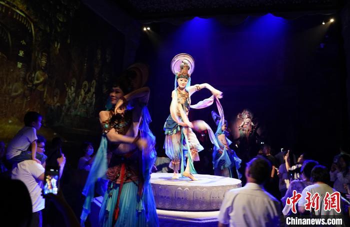 《樂動(dòng)敦煌》是全球首部洞窟式沉浸體驗(yàn)劇，利用真人與數(shù)字影像虛實(shí)交換實(shí)現(xiàn)沉浸式體驗(yàn)。圖為2023年8月28日晚，《樂動(dòng)敦煌》演出。(資料圖)中新社記者 毛建軍 攝